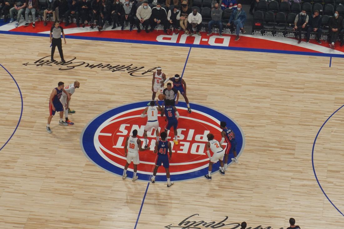 A jump ball at center court between the Knicks and Pistons