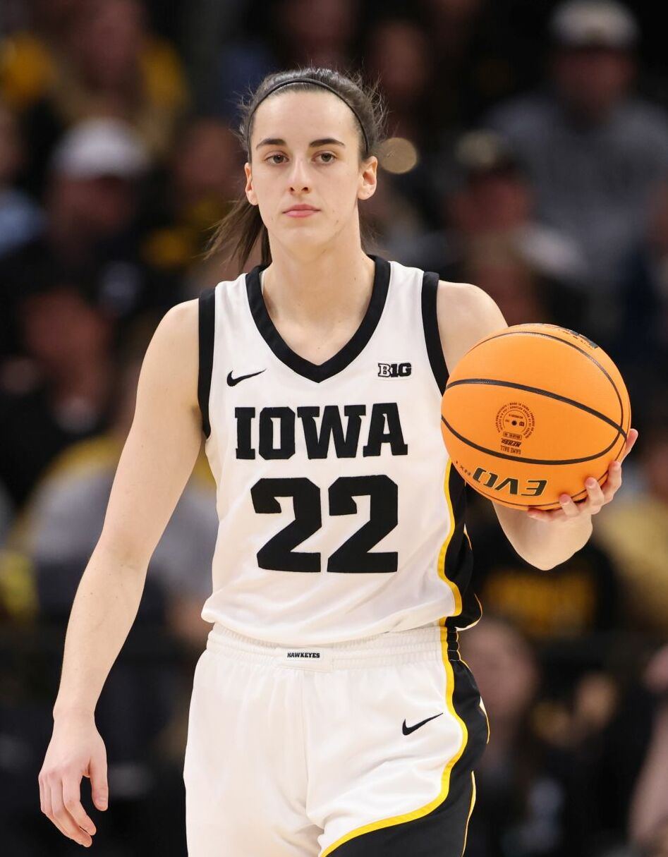 Caitlin Clark bringing the ball up for Iowa in a white number 22 jersey