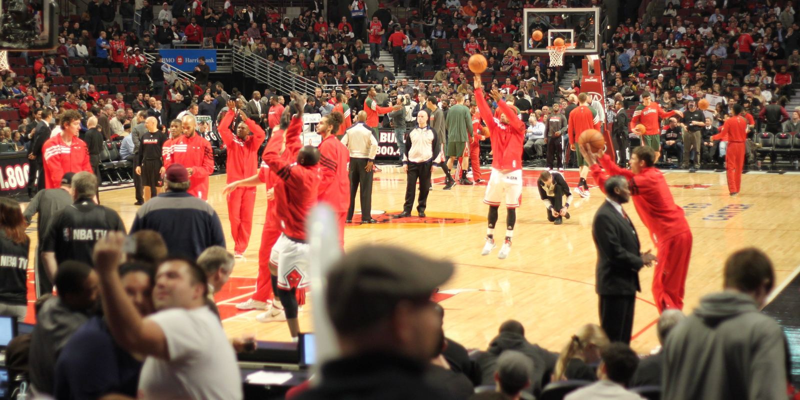 Chicago Bulls players in red warmups shooting before a game at the United Center