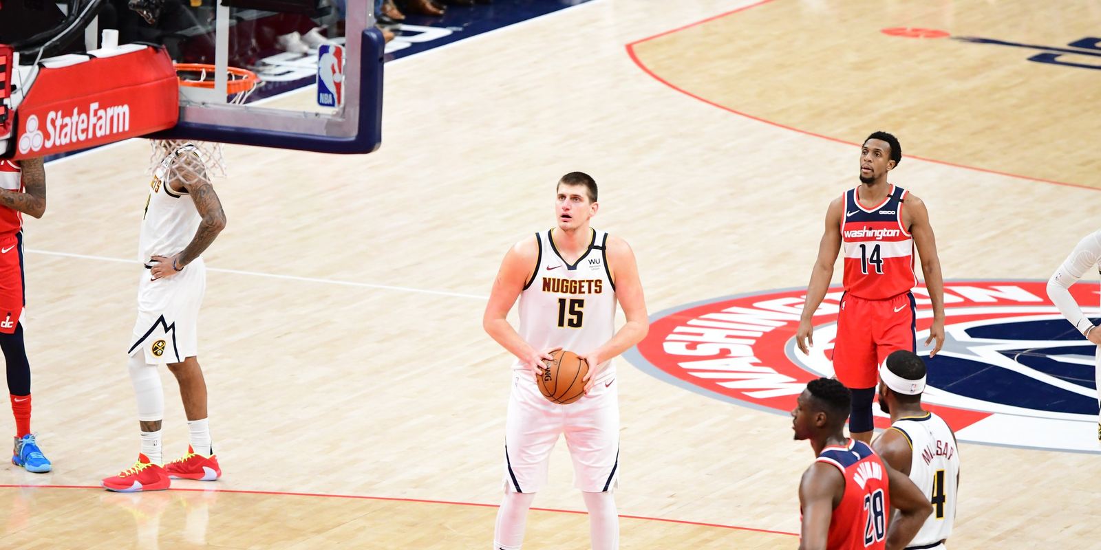 Nikola Jokic in a white Denver Nuggets jersey at the free throw line