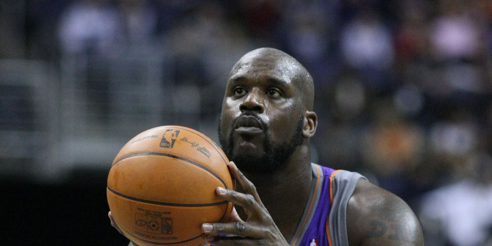 Shaquille O'Neal at the free throw line in a purple Phoenix Suns jersey