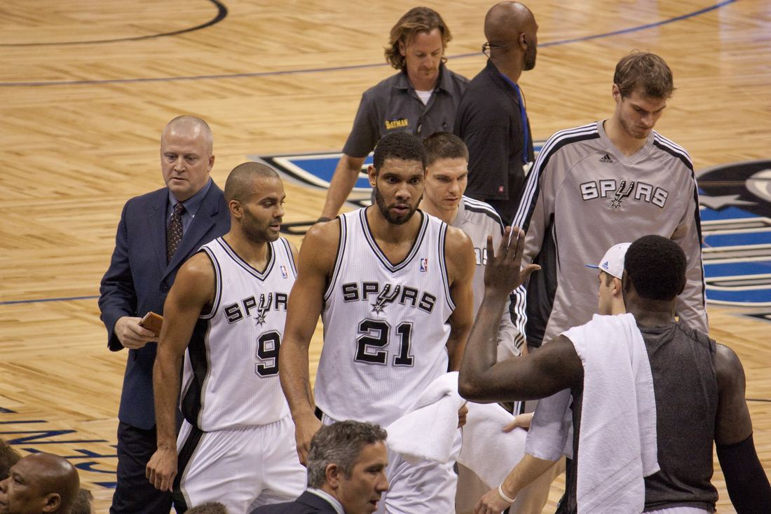 Tim Duncan walking toward the Spurs bench with teammates